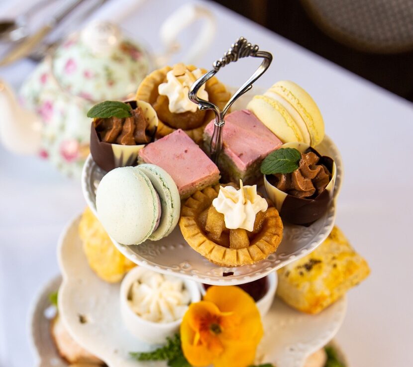 Delicious afternoon tea with sandwiches, pastries and drinks