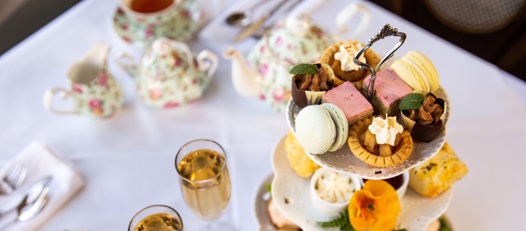 Delicious afternoon tea with sandwiches, pastries and drinks