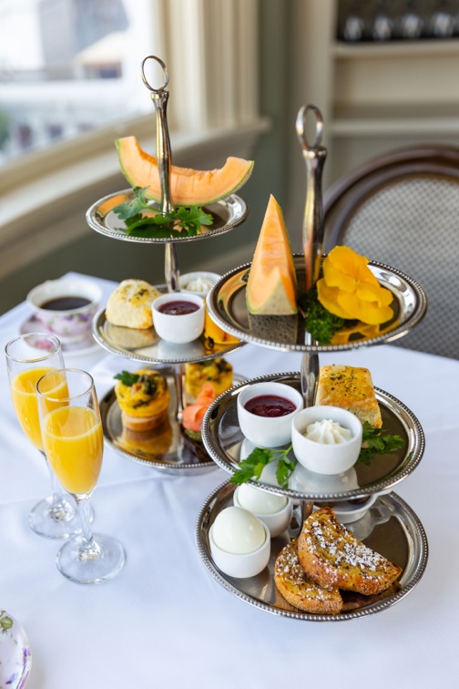 Delicious breakfast, eggs, pastries, tea and drinks on white tablecloth