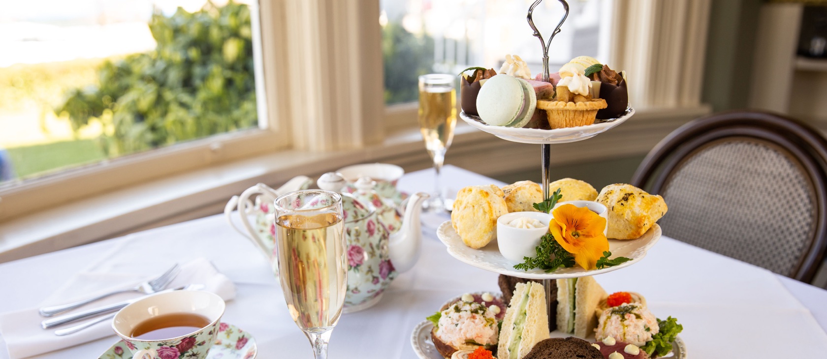 Delicious afternoon tea with sandwiches, pastries and drinks